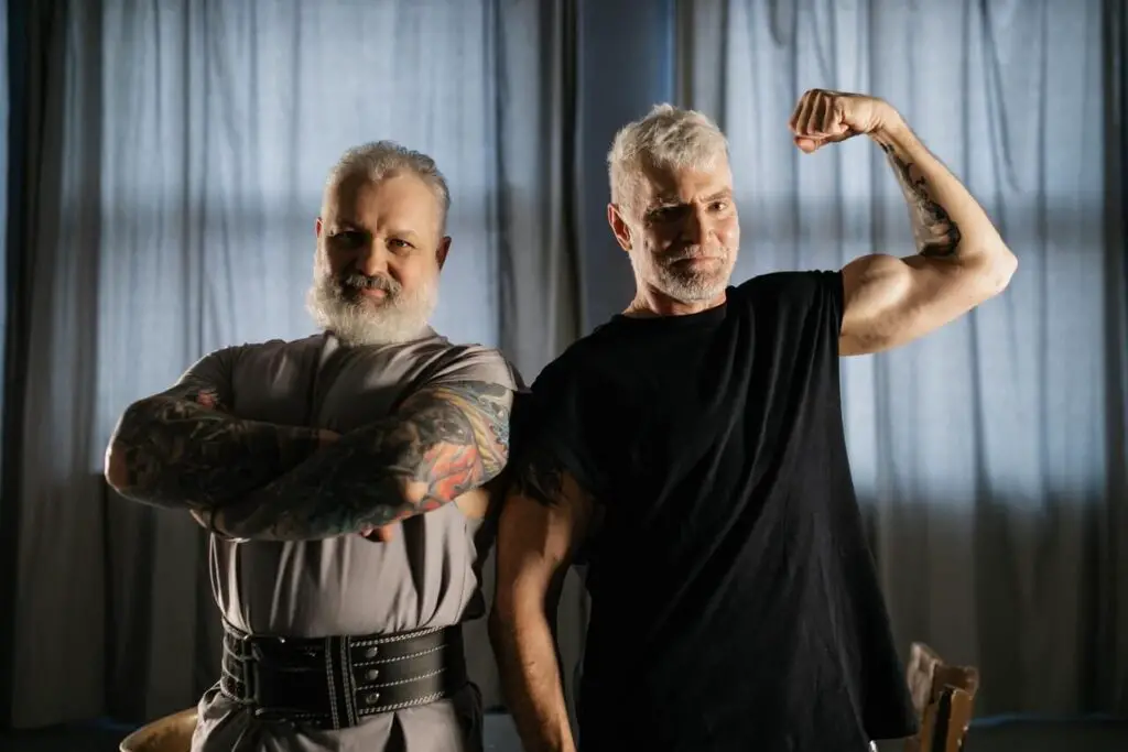 two elderly men showing off muscles