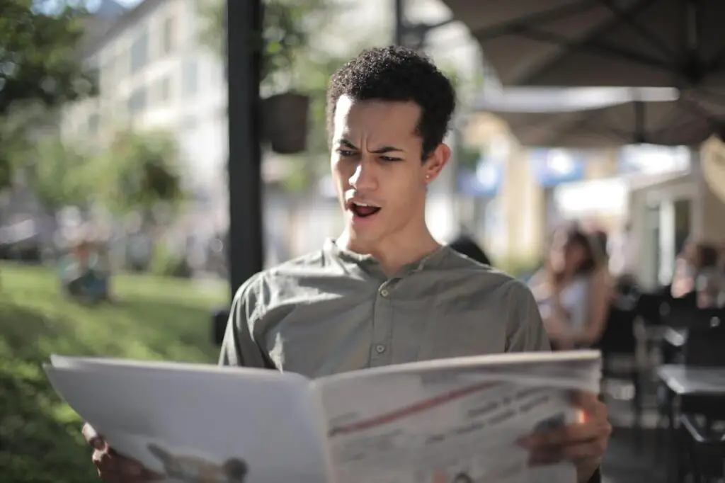 surprised man reading newspaper