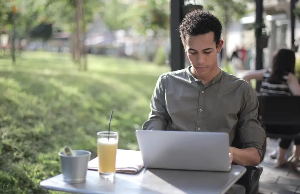 what should ectomorphs wear: skinny man wearing shirt and looking at laptop