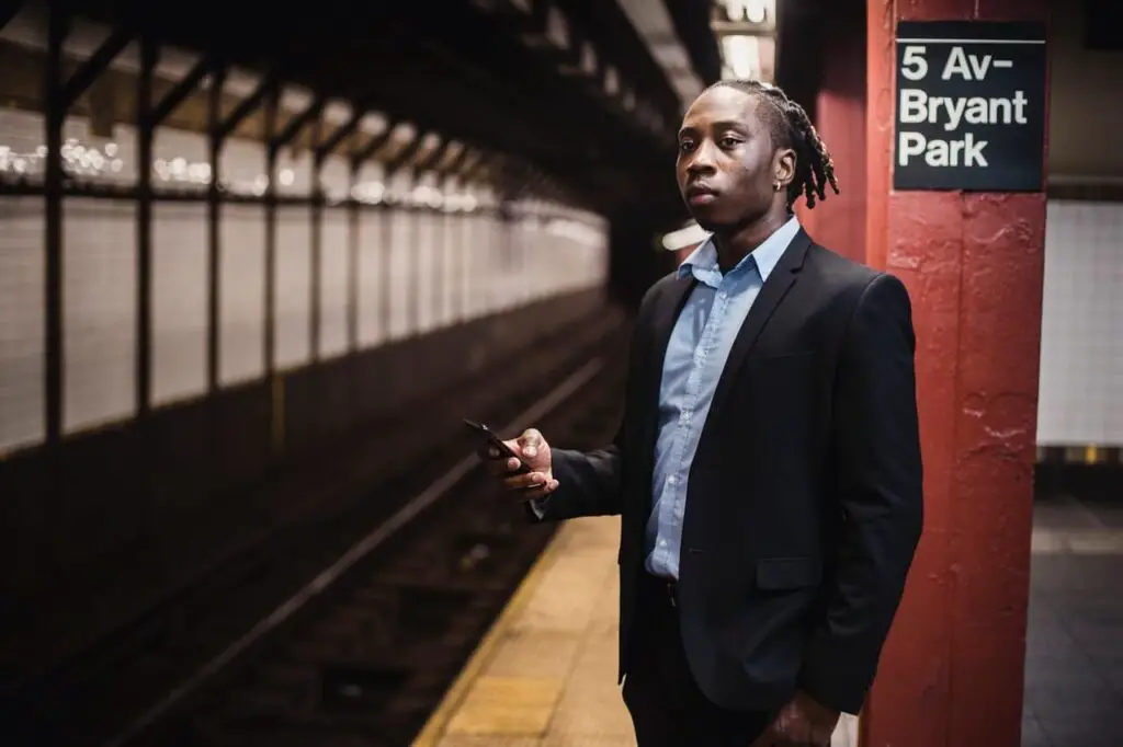 skinny guy holding phone and wearing slim fit shirt with jacket