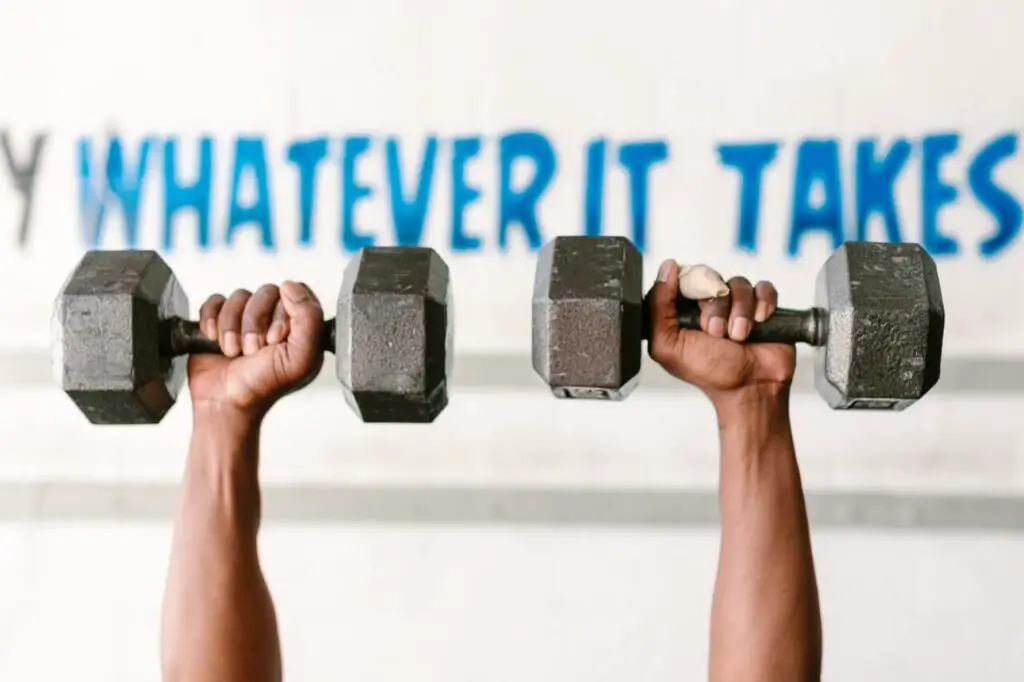 person lifting two heavy dumbbells